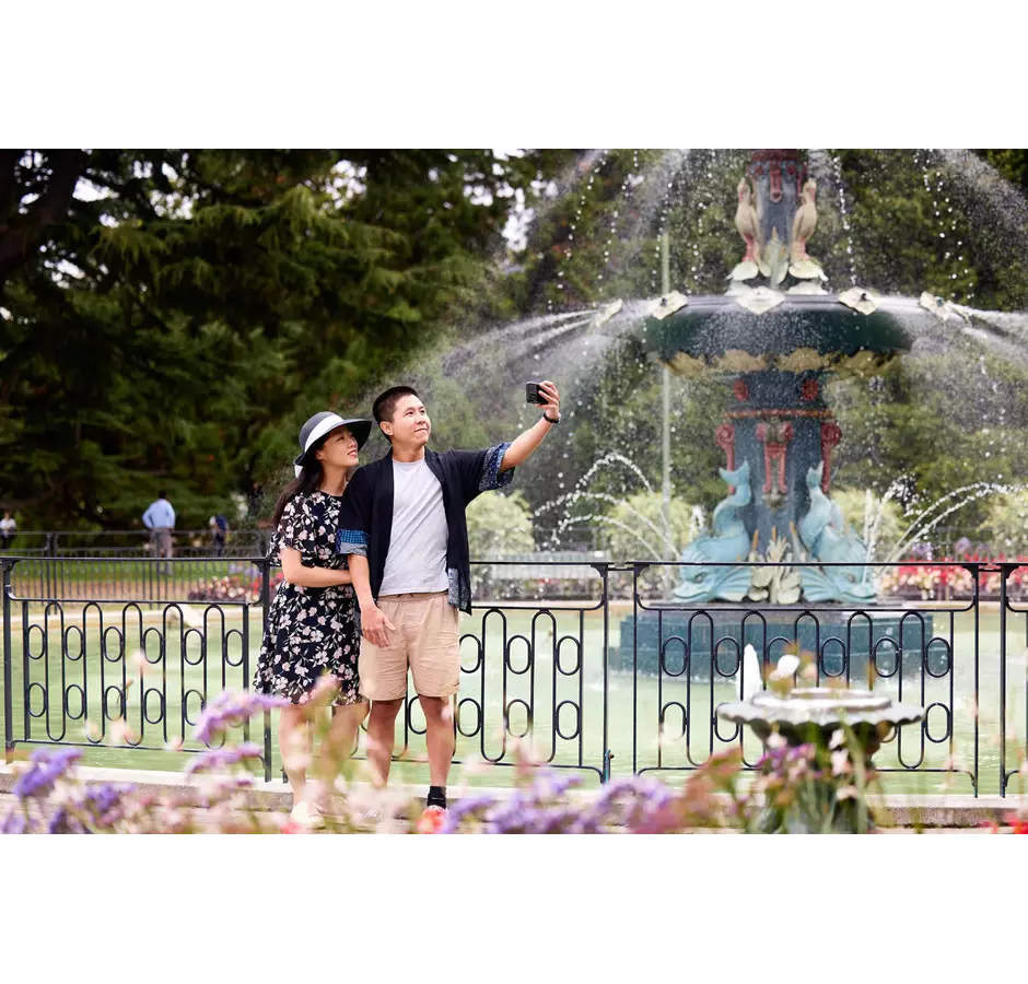 Couple Taking Photo At The Peacock Fountain Of The Botanic Gardens
