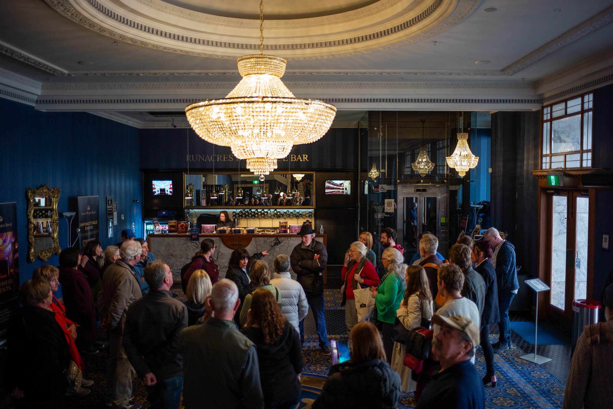 Isaac Theatre Royal group of people waiting in the lobby area with a bar in the background