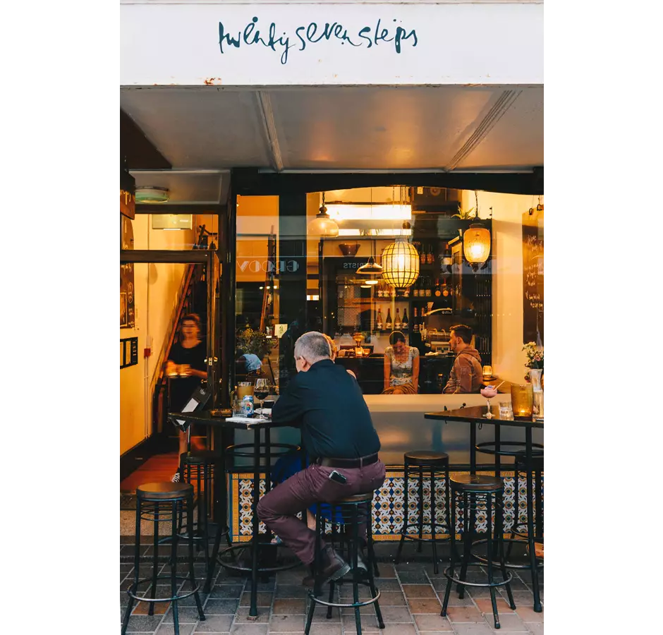 27 Steps Restaurant Downstairs Man Sitting On Chair Outside